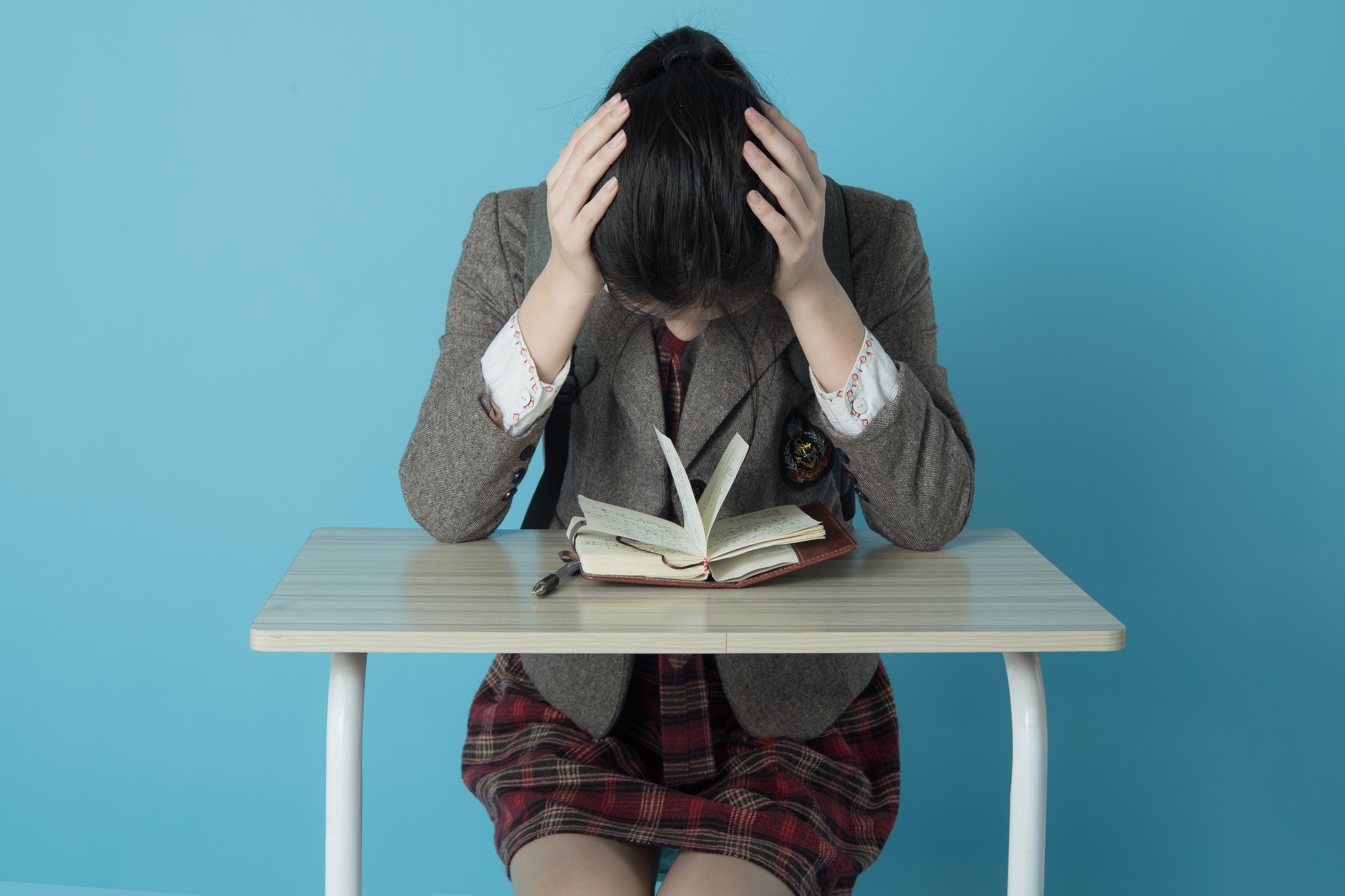 千库网_学生人像白天女学生室内双手挠头烦燥情绪摄影图配图_摄影图